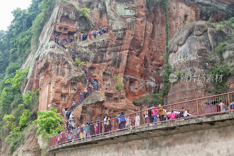 人们走过世界s最高的佛像在乐山，中国